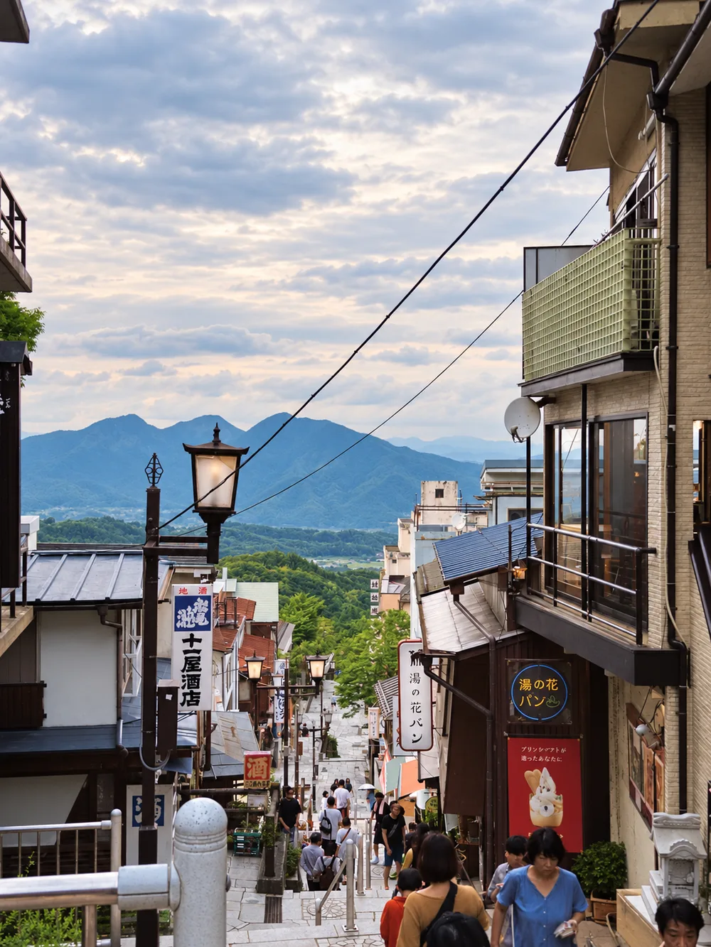 The stone steps street of Ikaho Onsen with mountains behind