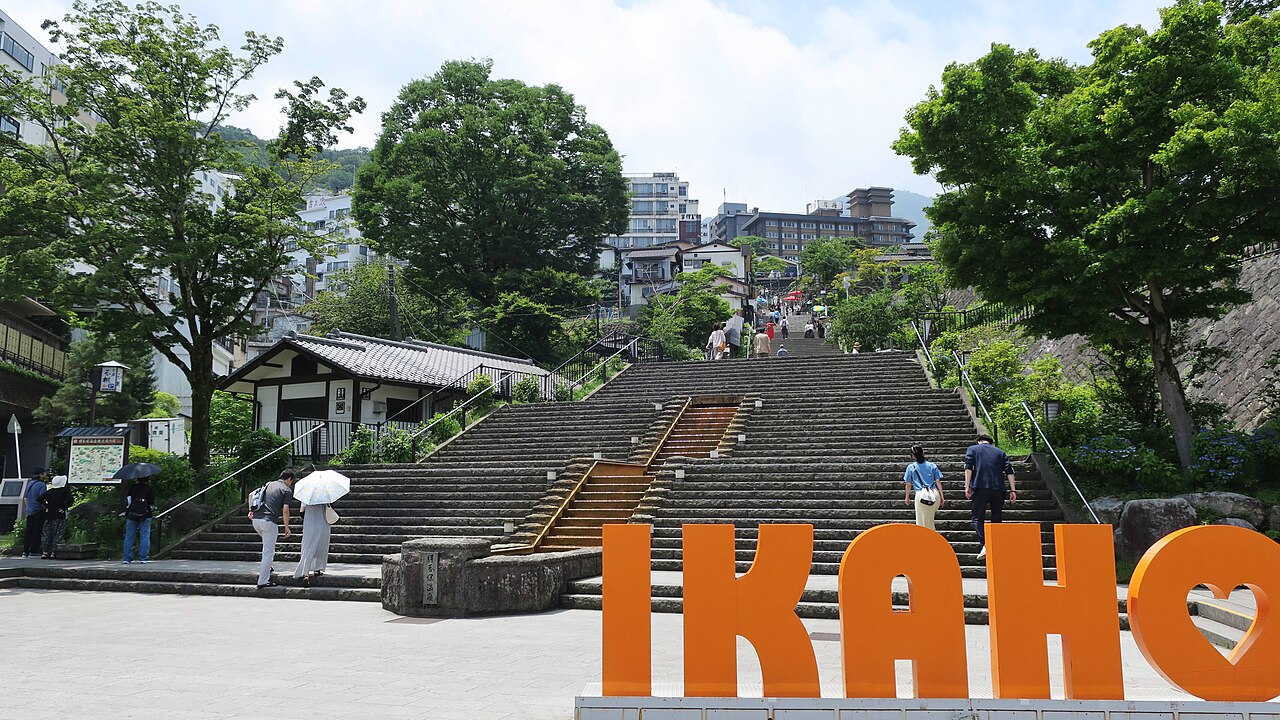 The Ikaho Onsen stone steps rising between trees, with the orange IKAHO sign in the foreground